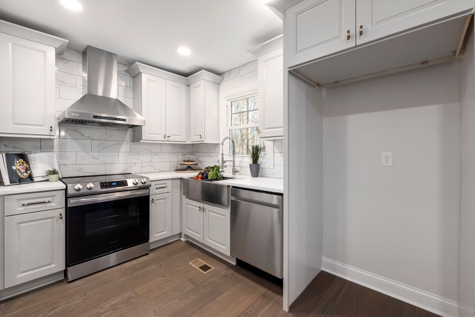 Bright, modern kitchen with stainless steel appliances and white cabinets in a minimalist style